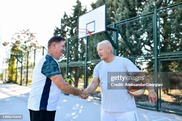 händedruck für ein spiel, das von zwei älteren männlichen basketballspielern gut gespielt wird - fairness stock-fotos und bilder