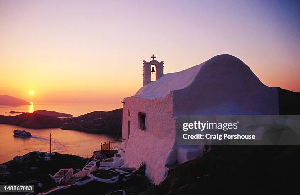 whitewashed hilltop church and aegean sea at sunset. - ios grécia imagens e fotografias de stock