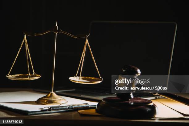 law books and scales of justice on desk in library of law firm jurisprudence legal education concept,romania - sentencing fotografías e imágenes de stock