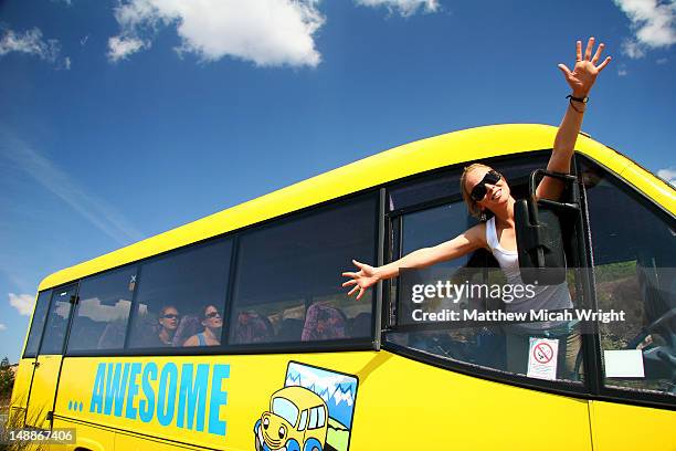 woman stretchers her arms out the front of the awesome bus. - ônibus de turismo - fotografias e filmes do acervo