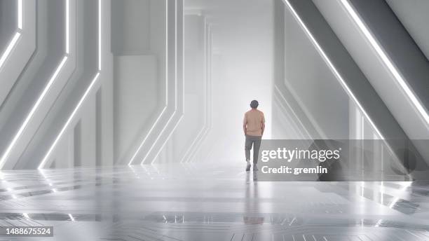 man walking in futuristic corridor - white light tunnel stock pictures, royalty-free photos & images