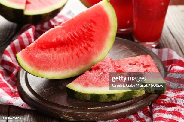 slices of watermelon on brown wooden background - melon stock pictures, royalty-free photos & images