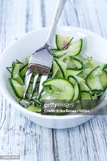 portion of fresh made cucumber salad with onions and dill,romania - azijn stockfoto's en -beelden