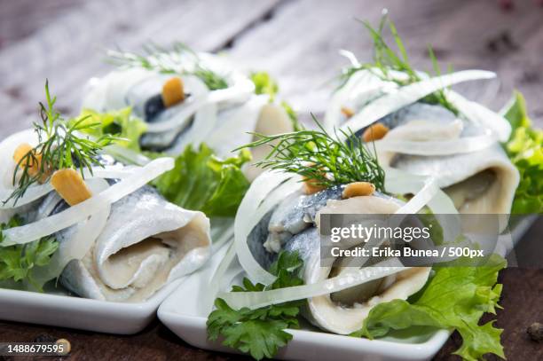 fresh made rollmop on a plate against wooden background,romania - räucherfisch stock-fotos und bilder
