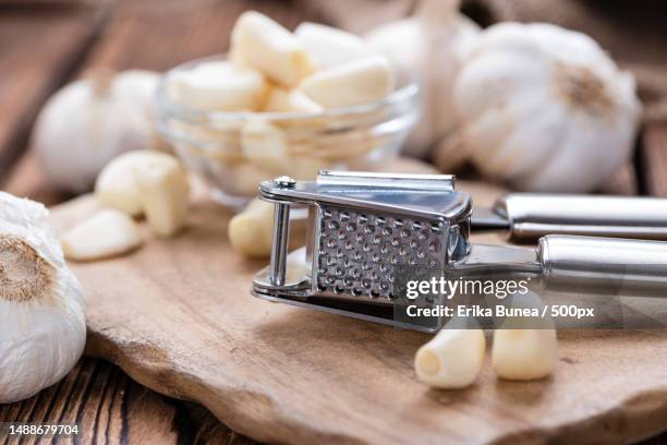 garlic press with fresh garlic on rustic wooden background,romania - ajo fotografías e imágenes de stock