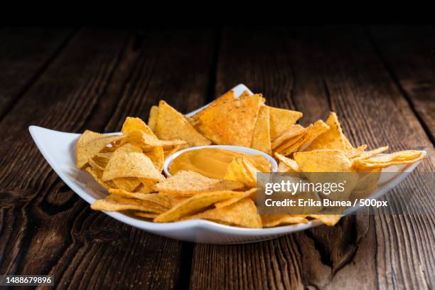 nachos with cheese dip close-up shot on an wooden table,romania - cheese sauce stock pictures, royalty-free photos & images