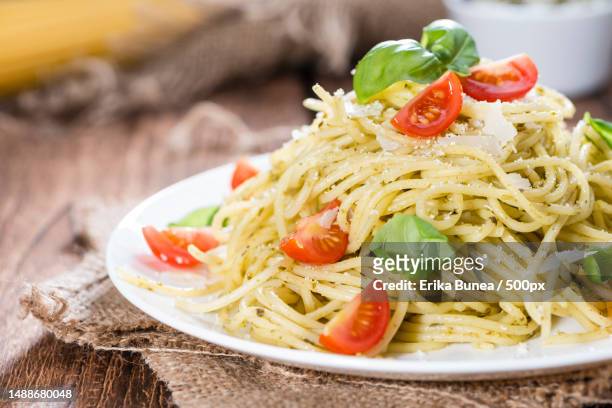 spaghetti with basil pesto,parmesan cheese and tomatoes,romania - spagetti stock pictures, royalty-free photos & images