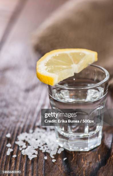 tequila silver with lemon and salt on vintage wooden background,romania - tequila stock-fotos und bilder