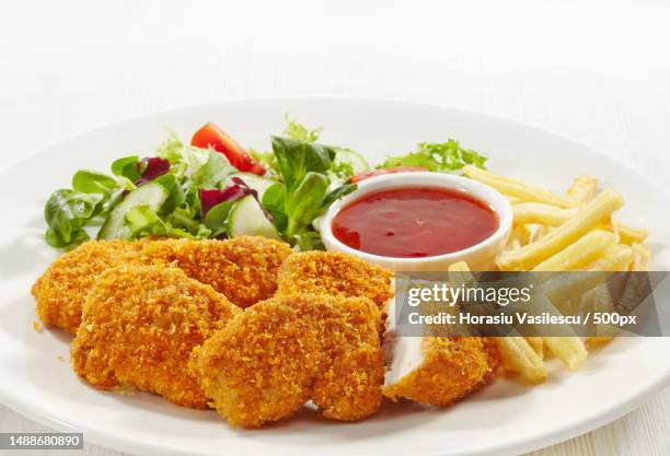 chicken nuggets and vegetables on a white plate - chicken nuggets ストックフォトと画像