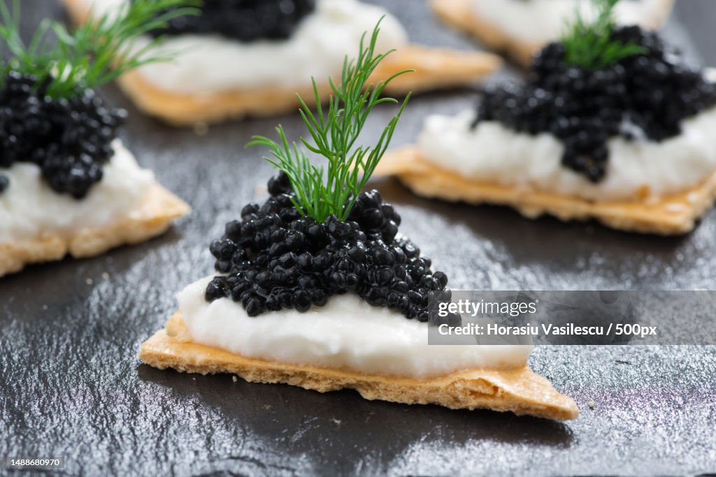 Crackers with cream cheese and black caviar,Horizontal