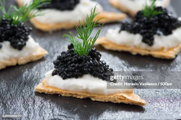 crackers with cream cheese and black caviar,horizontal - kaviaar stockfoto's en -beelden