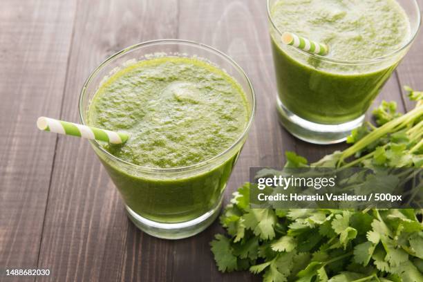 healthy green vegetables and green fruit smoothie on rustic wood table - avocado smoothie stock pictures, royalty-free photos & images