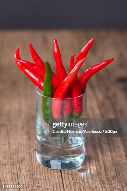 red chile pepper in glass on wooden background - jalapeno pepper ストックフォトと画像