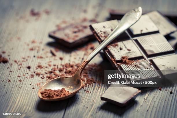cocoa powder on spoon and dark chocolate background - dark chocolate stock pictures, royalty-free photos & images