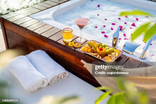 pool cocktails with fruit platter placed next to a spa's rooftop  bathtub - hot tub party stock pictures, royalty-free photos & images