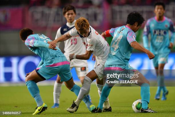 Yoichiro Kakitani of Cerezo Osaka competes for the ball against Ryuhei Niwa and Naoyuki Fujita of Sagan Tosu during the J.League J1 match between...