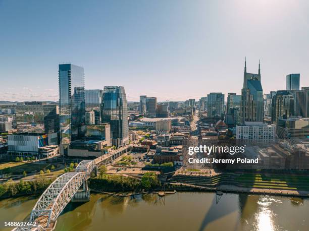 aerial view of broadway, the tourism center of downtown nashville, tennessee on a sunny springtime afternoon from the north side of the cumberland river near nissan stadium - nashville stockfoto's en -beelden