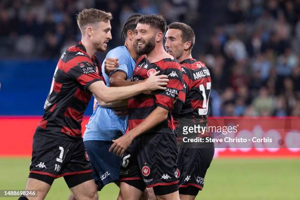 Brandon Borrello of the Wanderers is pushed away by team-mate Thomas Beadling after a heated exchange of words with Sydney FC's Luke Brattan during...