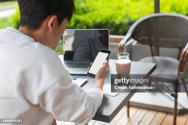 mani che tengono il telefono cellulare nero con schermo desktop vuoto mentre bevono caffè - http foto e immagini stock