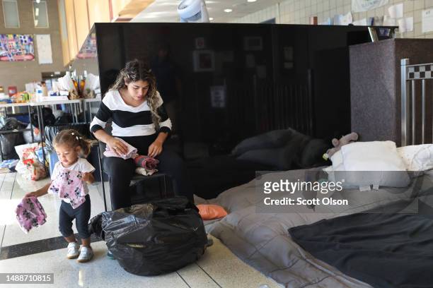 Migrant mother from Venezuela, who is seven months pregnant, rests with her 17-month-old daughter in the lobby of a police station where they have...