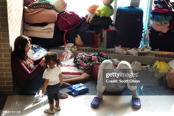 Immigrants from Venezuela rest in the lobby of a police station where they have been staying with other migrant families since their arrival to the...