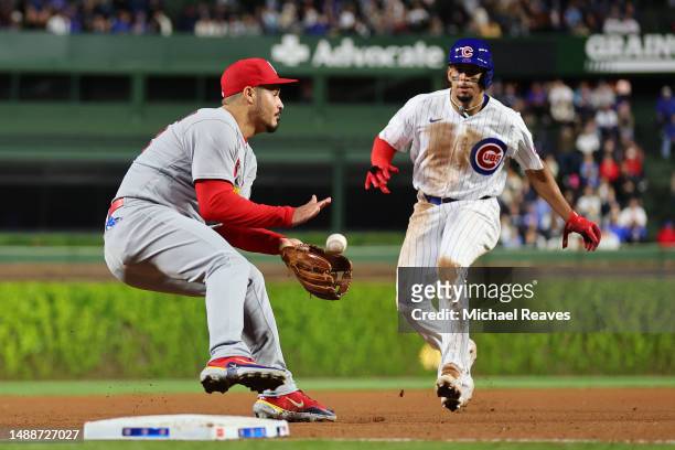 Nolan Arenado of the St. Louis Cardinals fields a ground ball and tags out Christopher Morel of the Chicago Cubs during the eighth inning at Wrigley...