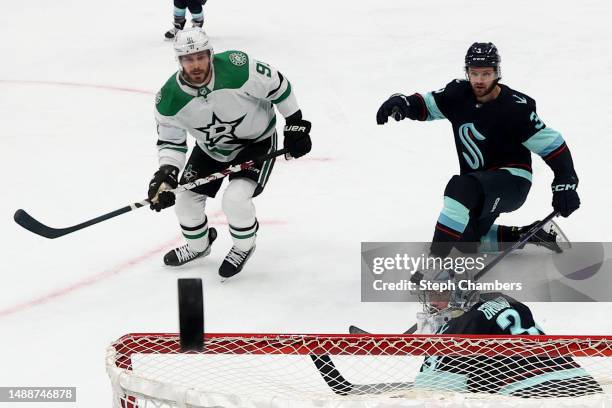 Philipp Grubauer and Will Borgen of the Seattle Kraken watch the puck miss the crossbar against Tyler Seguin of the Dallas Stars during the first...