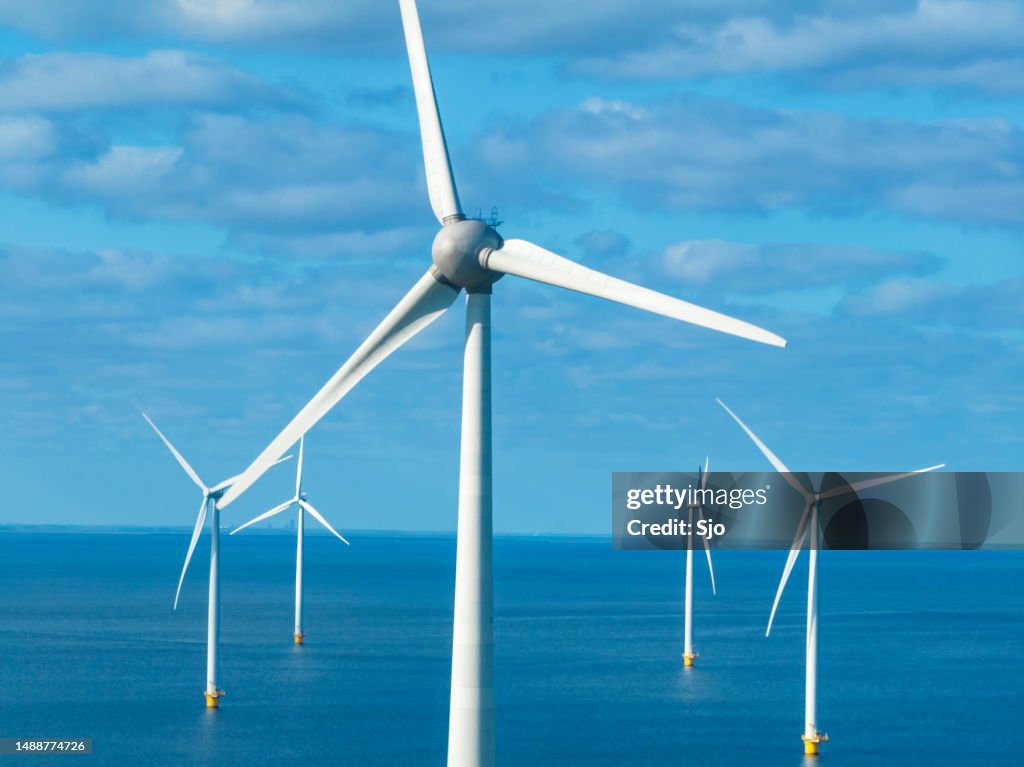 Wind turbines in an offshore wind park during springtime seen from above