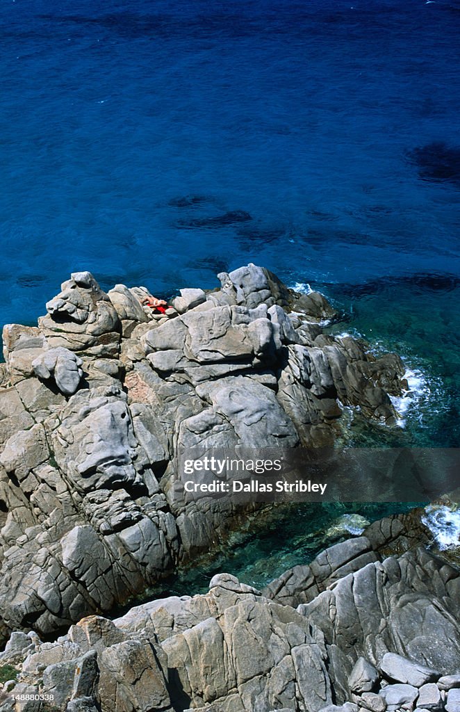 Turquoise waters and sunbathers on the rocky coast of Santa Teresa di Gallura.