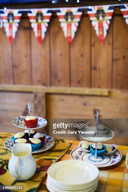 coronation celebration, close-up of traditional cakes and union jack bunting - british flag cake stock pictures, royalty-free photos & images