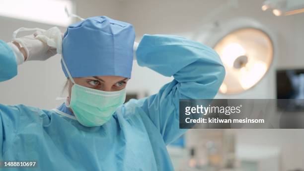 females surgical specialist, professional doctor, medical worker wearing sterile surgical uniform and medical mask preparing for surgery on the patient in modern operating room at hospital. concept of health care, hospital. - sala limpa imagens e fotografias de stock