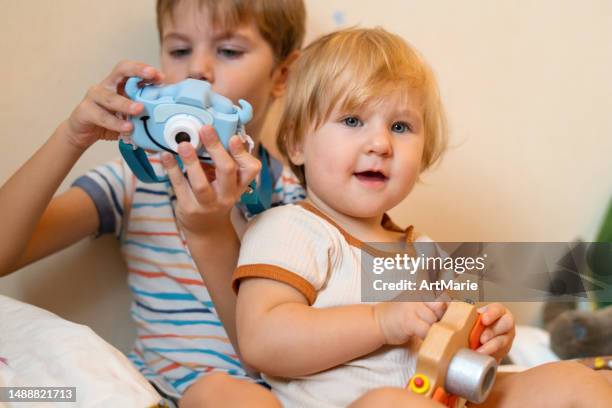 little photographers: little girl and her brother with toy cameras at home - toy camera stock pictures, royalty-free photos & images