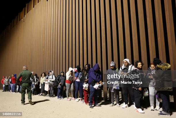 Immigrants seeking asylum in the United States are processed by U.S. Border Patrol agents in the early morning hours after crossing into Arizona from...