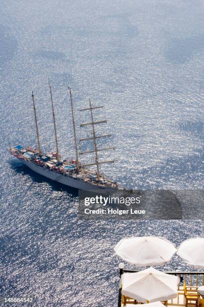 overhead of star clippers' star flyer' sailing ship, with caft umbrellas in foreground, fira. - caft stock pictures, royalty-free photos & images