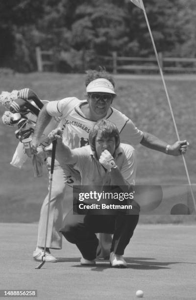 Bob Gilder gets assistance lining up putts from his caddie, C. Carolan.