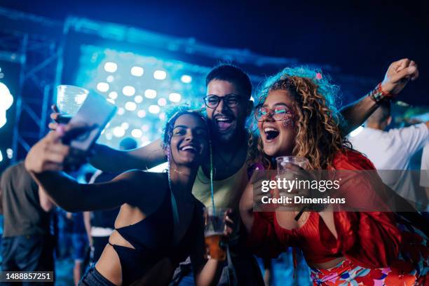 friends taking selfie at music festival. - selfie phone stock pictures, royalty-free photos & images