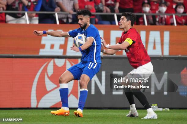 ASaleh Alshehri of Al-Hilal in action under pressure from Hiroki Sakai of Urawa Red Diamonds during the AFC Champions League final second leg between...