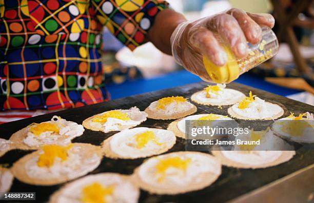 woman prepares popular market fritter, mung bean biscuits at nightcliff market. - northern territory stock-fotos und bilder