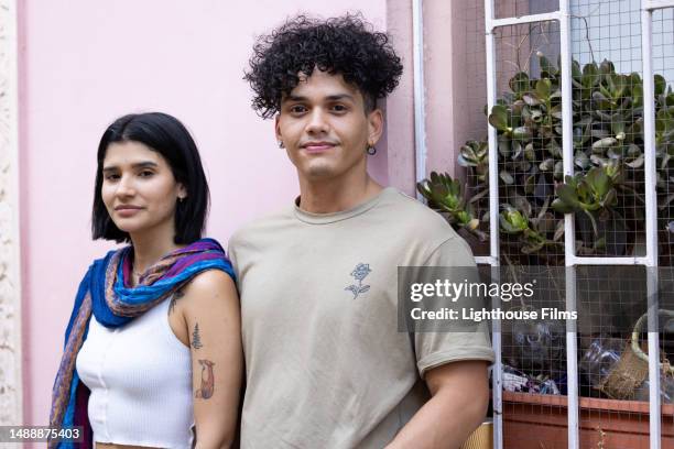 a young latin heterosexual couple stands against a pink wall in santiago, chile - medium shot stock pictures, royalty-free photos & images