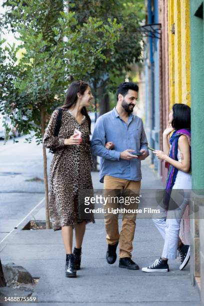 a young woman looks up to greet her friends as they say hello - chilean ethnicity stock pictures, royalty-free photos & images