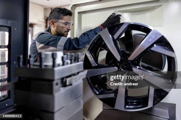 mechanic testing an alloy wheel at a car garage - alloy stock pictures, royalty-free photos & images
