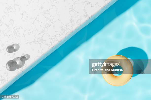 swimming pool with blue water and yellow inflatable ring in sun. concept of harmony, rest, vacation and summer. 3d background. - bordo piscina foto e immagini stock