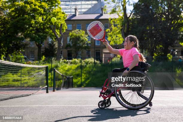 determined to get the ball - wheelchair tennis stockfoto's en -beelden