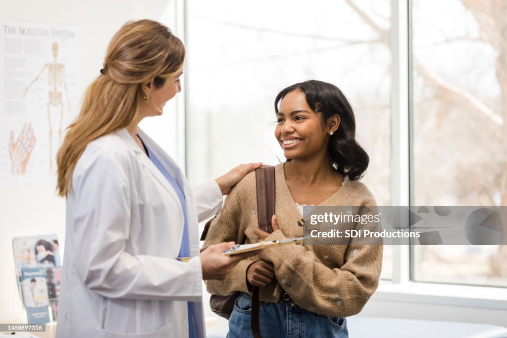 Ärztin lächelt und gratuliert Studentin
