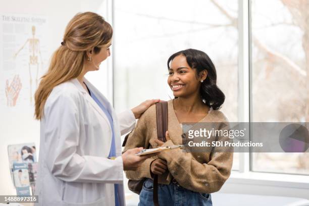 female doctor smiles and congratulates female college student - ssc exam stock pictures, royalty-free photos & images