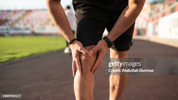 unrecognizable sports man injures his knee while jogging - bone 個照片及圖片檔