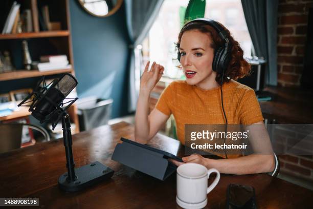 woman doing a solo podcast from her studio in los angeles, california - commentator imagens e fotografias de stock