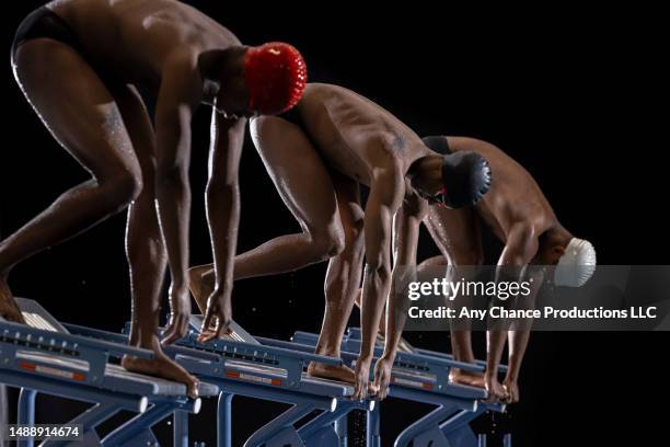 male swimmers getting set for a race. - man muscular build stock pictures, royalty-free photos & images