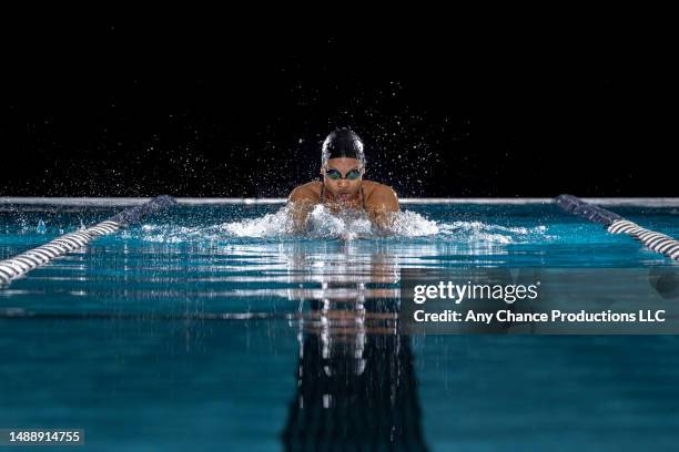 head on angle of a female black swimming using breaststroke - nadador fotografías e imágenes de stock