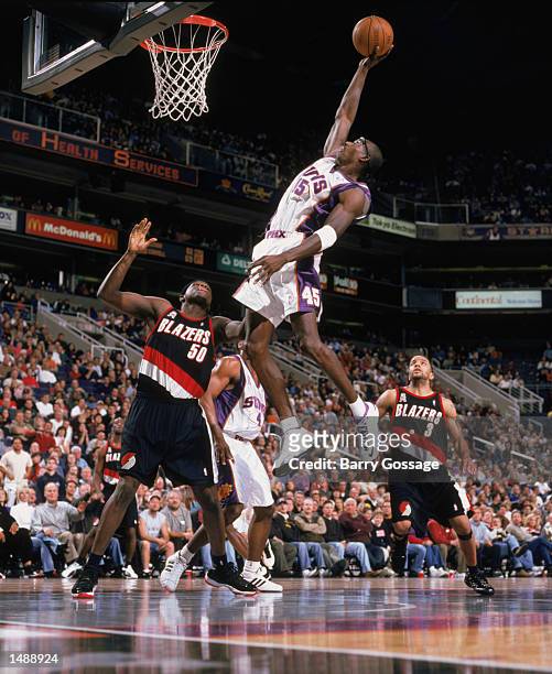 Forward Bo Outlaw of the Phoenix Suns dunks the ball as forward Zachary Randolph of the Portland Trail Blazers stands under the basket during the NBA...
